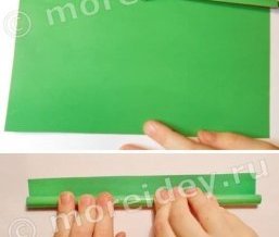 Разрезать лист зеленой бумаги пополам. Одну половину отложить, другую с помощью карандаша скатать в тонкую трубочку. Карандаш вынуть. На край бумаги нанести клей и склеить трубочку. Это будет цветочный стебель.